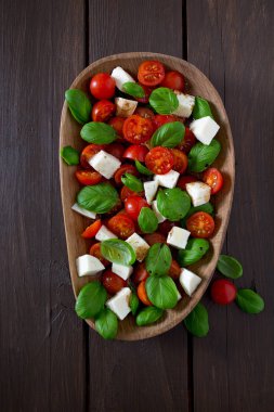 Koyu ahşap yüzeyde Caprese salatası