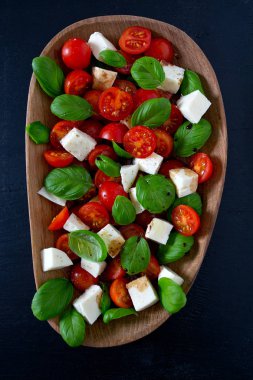 Koyu ahşap yüzeyde Caprese salatası