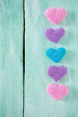 turuoise ahşap yüzeyde örme kalpler