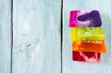 Turuoise ahşap yüzeyinde renkli el yapımı sabunlar.