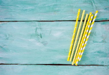 Turkuaz ahşap zemin üzerine sarı çizgili kağıt payet