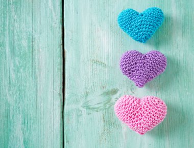 turuoise ahşap yüzeyde örme kalpler