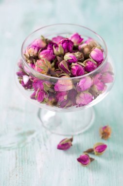 Turkuaz ahşap yüzeyde kurumuş gül tomurcukları