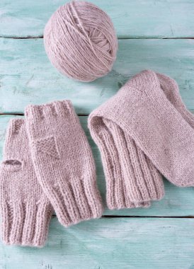 Turkuaz ahşap arka planda örülmüş kıyafetler.