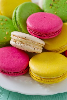 Turkuaz ahşap yüzeyde çok renkli macaroons