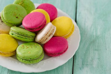 Turkuaz ahşap yüzeyde çok renkli macaroons
