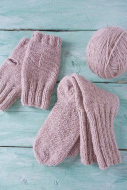 Turkuaz ahşap arka planda örülmüş kıyafetler.