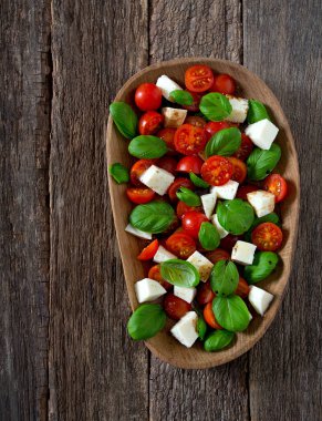 Koyu ahşap yüzeyde Caprese salatası