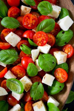 Koyu ahşap yüzeyde Caprese salatası