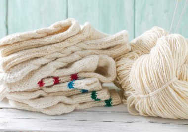 Turkuaz ahşap arka planda örülmüş kıyafetler.