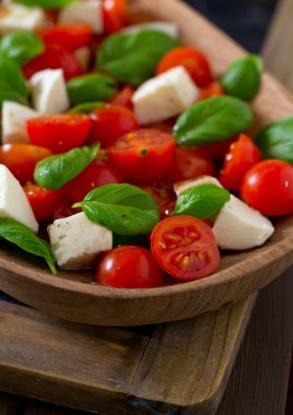 Koyu ahşap yüzeyde Caprese salatası