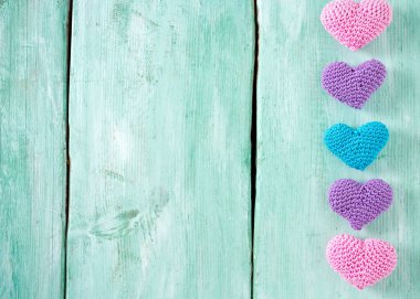 turuoise ahşap yüzeyde örme kalpler