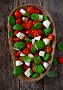 Koyu ahşap yüzeyde Caprese salatası