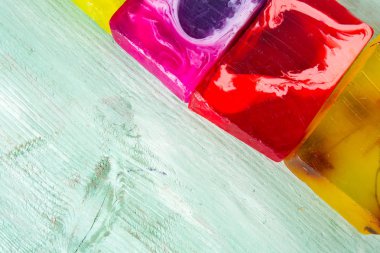 Turuoise ahşap yüzeyinde renkli el yapımı sabunlar.