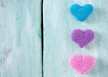 turuoise ahşap yüzeyde örme kalpler