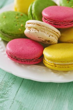 Turkuaz ahşap yüzeyde çok renkli macaroons