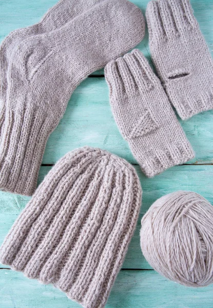 Turkuaz ahşap arka planda örülmüş kıyafetler.