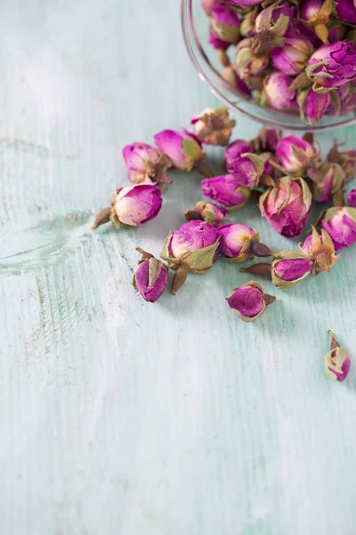 Turkuaz ahşap yüzeyde kurumuş gül tomurcukları