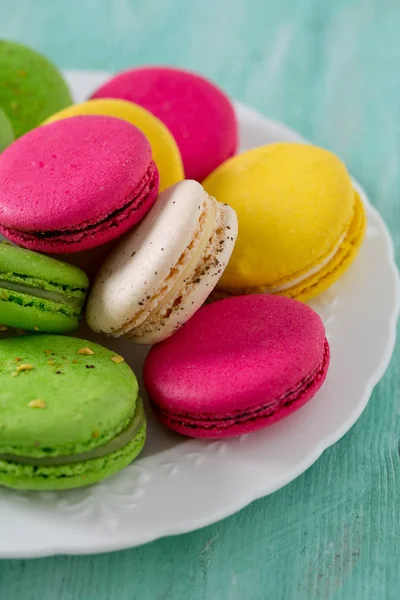 Turkuaz ahşap yüzeyde çok renkli macaroons
