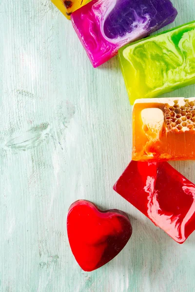 Turuoise ahşap yüzeyinde renkli el yapımı sabunlar.