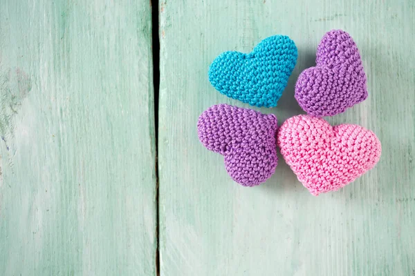 turuoise ahşap yüzeyde örme kalpler