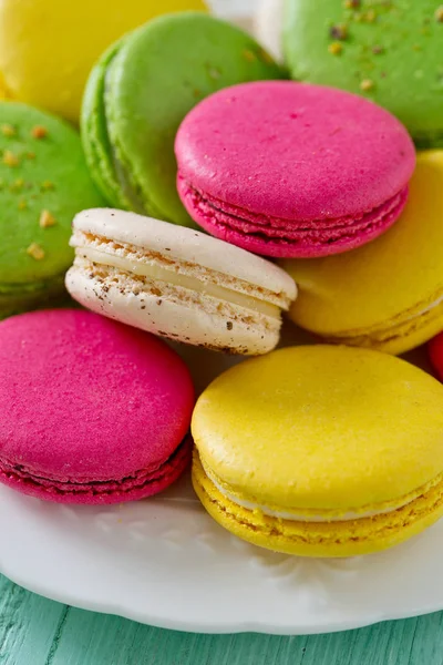 Turkuaz ahşap yüzeyde çok renkli macaroons
