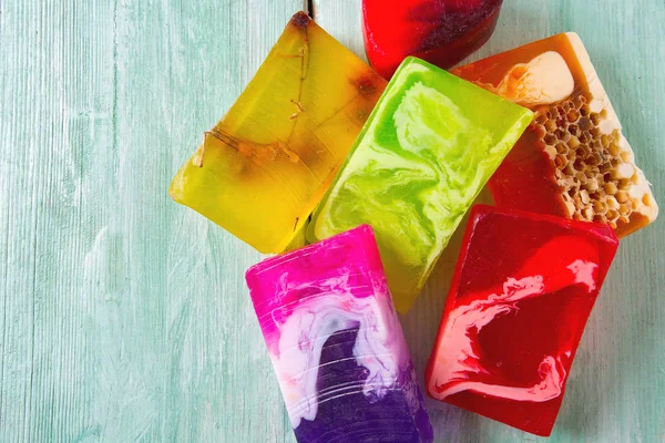 Turuoise ahşap yüzeyinde renkli el yapımı sabunlar.
