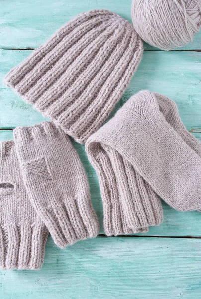 Turkuaz ahşap arka planda örülmüş kıyafetler.