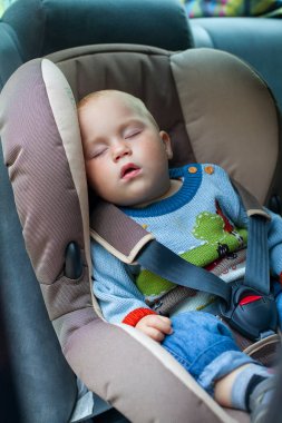 Küçük çocuk bir araba koltuğunda uyuyan