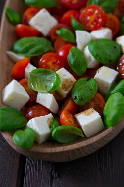 Koyu ahşap yüzeyde Caprese salatası