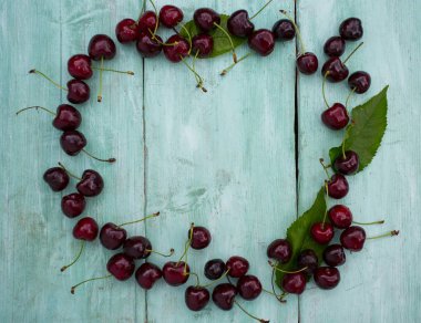 Turkuaz ahşap yüzeyde kirazlar