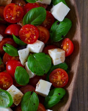 Koyu ahşap yüzeyde Caprese salatası