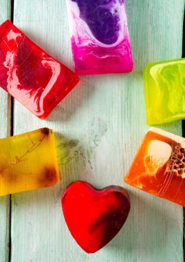 Turuoise ahşap yüzeyinde renkli el yapımı sabunlar.