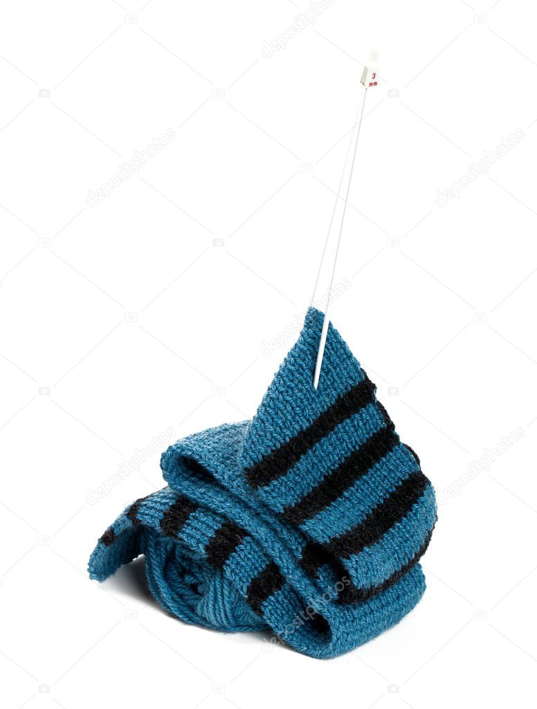 striped scarf on knitting needles over white