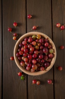 Ahşap yüzeyde bir kasede kırmızı bektaşi üzümü