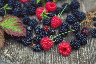 Eustik ahşap yüzeyde taze ahududu ve böğürtlen