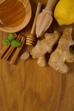 Ahşap kesme tahtası üzerinde bal, limon ve zencefil üstten görünüm