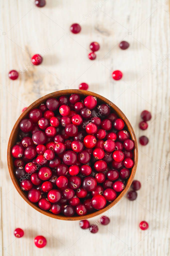 fresh red cranberries on white wooden surface