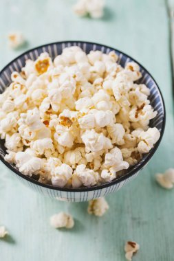 kase tuzlu patlamış mısır ile turkuaz ahşap yüzey üzerinde görmek