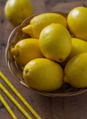 ahşap yüzey üzerinde hasır kasede limon