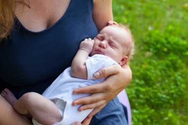 Bebek anne ellerinin üzerinde açık uyuyor