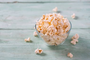 kase tuzlu patlamış mısır ile turkuaz ahşap yüzey üzerinde görmek