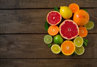 koyu ahşap zemin üzerine karışık narenciye üstten görünüm