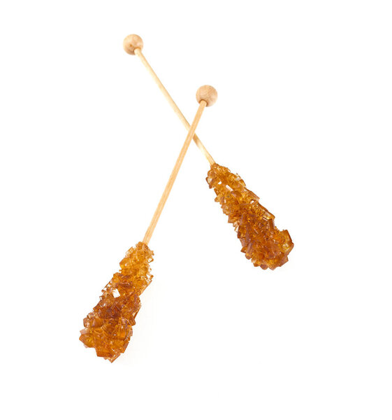 Кирпичный янтарный кристалл сахара на деревянной палочке
