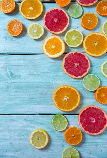 top view of citrus fruit slices on turquoise wooden background