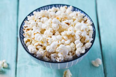 Turkuaz ahşap yüzeyde tuzlu popcorn