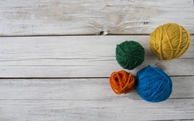 Beyaz ahşap yüzey üzerinde renkli iplik topları