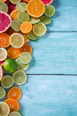Narenciye meyve dilimleri üstten görünüm turkuaz ahşap zemin üzerine