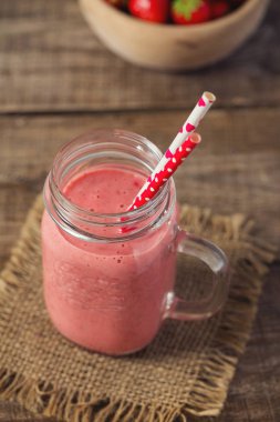 Tahta yüzeyde çilekli milkshake.