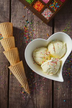 Lezzetli vanilyalı dondurma ve waffle koniler ahşap tablo